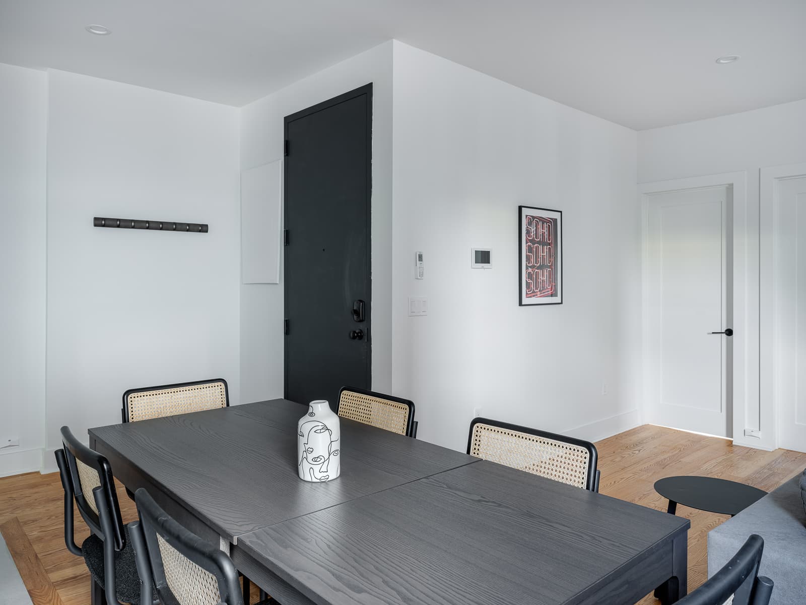 Dining area facing the black front door with keyless lock and coat rail
